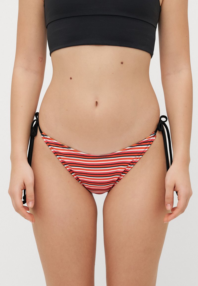 Bikini spodnjice z raznobarvnimi rdečimi, belimi in črnimi črtami; vsebujejo stranske zaveze in nizko zasnovo. Tekstilirana tkanina.