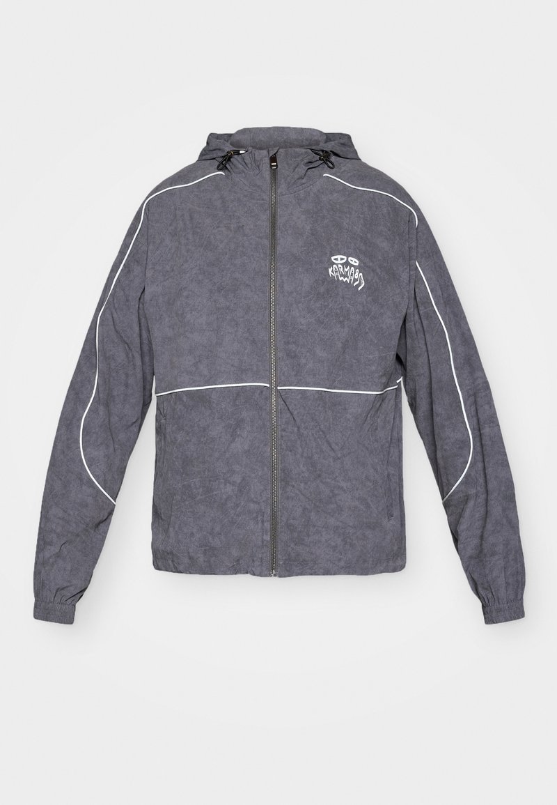 Gray windbreaker jacket with a textured finish, zip closure, hood, and white accent piping; features a small logo on the chest.
