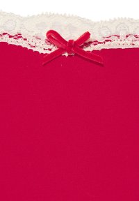 Punainen kangas poimutetulla tekstuurilla, jossa on valkoinen pitsireunus ja pieni punainen nauhansolmu keskellä ylhäällä.