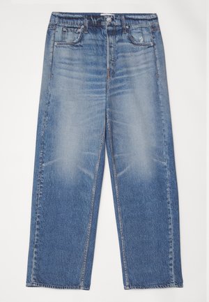 Plave traperice s opuštenim krojem, izblijedjelim prednjim dijelom, pet džepova i zatvaranjem na gumb. Ima srebrni gumb i kontrastne šavove.