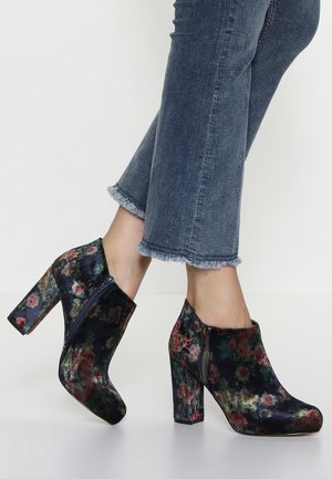 Floral-patterned ankle boots in dark velvet with a side zipper and a block heel. Features a rounded toe and a textured surface.