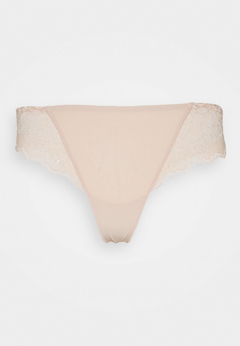 Beige tanga med spetsdetaljer och en mjuk, genomskinlig tyg. Har en scallop-mönstrad spets längs kanterna. Enfärgad design med minimalistisk stil.