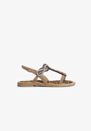 Tan sandal with a T-strap design, embellished with beaded accents, featuring a leopard-print insole and a flat rubber sole.