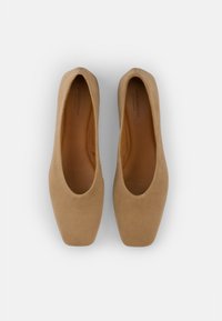 Beige semskede ballettsko med rund tå og glatt tekstur, med lavt snitt og en enkel silhuett.
