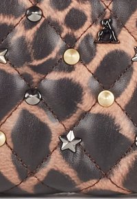 Torba z pikowanej skóry z wzorem w panterkę, z ozdobami w kolorze złotym, czarnym i srebrnym, o chropowatej powierzchni i diamentowym przeszyciu.
