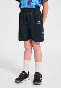 Svarta sportshorts med elastisk midja, med blå logotyp och detaljer, matchat med vita strumpor och svarta träningsskor.