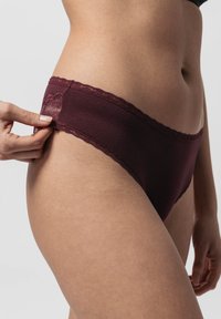 Mutande in tessuto bordeaux con bordo in pizzo; texture morbida; cintura regolabile a mano; design semplice; vestibilità tipica.