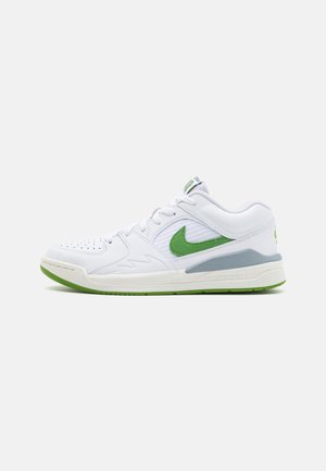 Niski biały sneaker z zielonym logo Nike, szarym detalem na śródpodeszwie i zielonym spodem, pokazany z boku na jasnym tle.