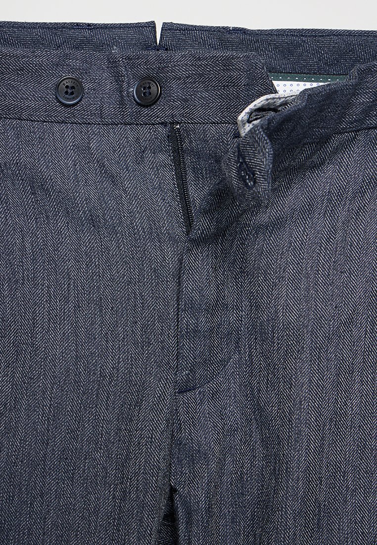Dunkelblaue Herringbone-Stoffhosen mit zwei schwarzen Knöpfen, einem Reißverschluss und einer glatten Textur mit subtilen Mustern.