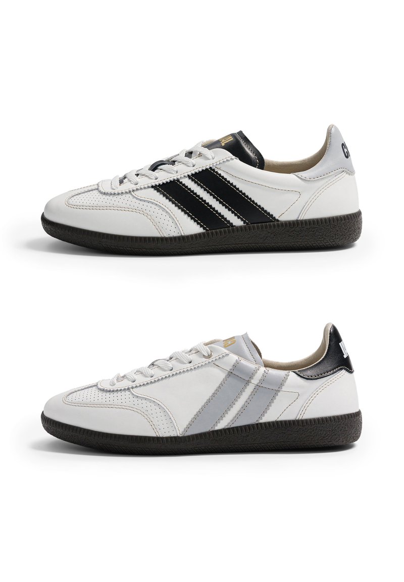Deux baskets basses blanches avec semelles noires, l'une avec des doubles bandes noires, l'autre avec des doubles bandes grises, vues de profil face à gauche.