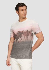T-shirt en coton gris et rose clair avec un imprimé photographique de chevaux en train de courir, col rond et manches courtes.