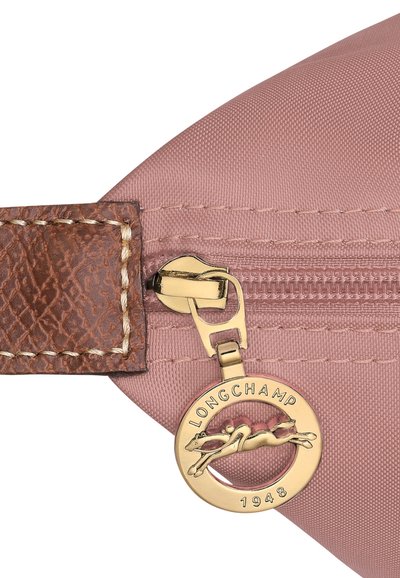 Rosa Nylon-Tasche mit einem strukturierten braunen Ledergriff und goldenem Reißverschluss. Verfügt über einen kreisförmigen goldenen Anhänger mit einem laufenden Pferdelogo.