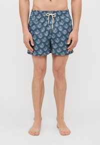 Männerbadehosen in Dunkelblau mit weißem Blumenmuster. Leichtes Material, elastischer Bund mit Kordelzug, Länge über dem Knie und glatte Textur.