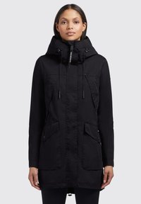 Parka noire avec capuche, dotée de poches avant, de cordons de serrage et d'une fermeture éclair. Réalisée en tissu texturé et résistant à l'eau.