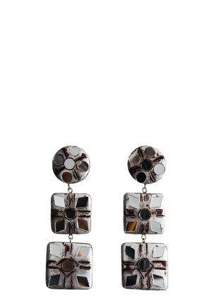 Boucles d'oreilles argentées pendantes avec des parties supérieures circulaires et deux segments carrés en dessous, présentant des découpes géométriques et des motifs de croix gravés.