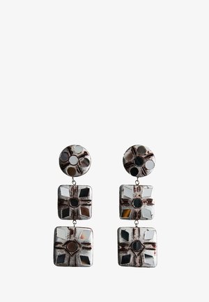 Boucles d'oreilles argentées pendantes avec des parties supérieures circulaires et deux segments carrés en dessous, présentant des découpes géométriques et des motifs de croix gravés.