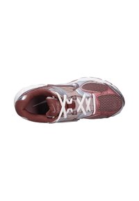 Nike tenisky s maroonovou a stříbrnou síťovinou, bílé šňůrky, polstrovaný límec a texturovaná gumová podrážka. Mají větrané panely pro prodyšnost.