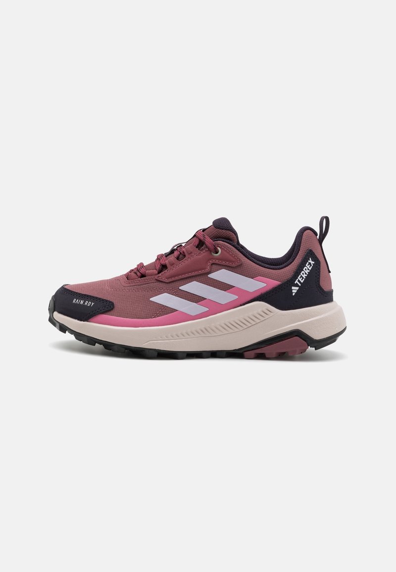 Chaussure de trail Adidas Terrex bordeaux et rose avec des bandes blanches, une semelle noire et le texte « Rain.RDY » sur le bout.