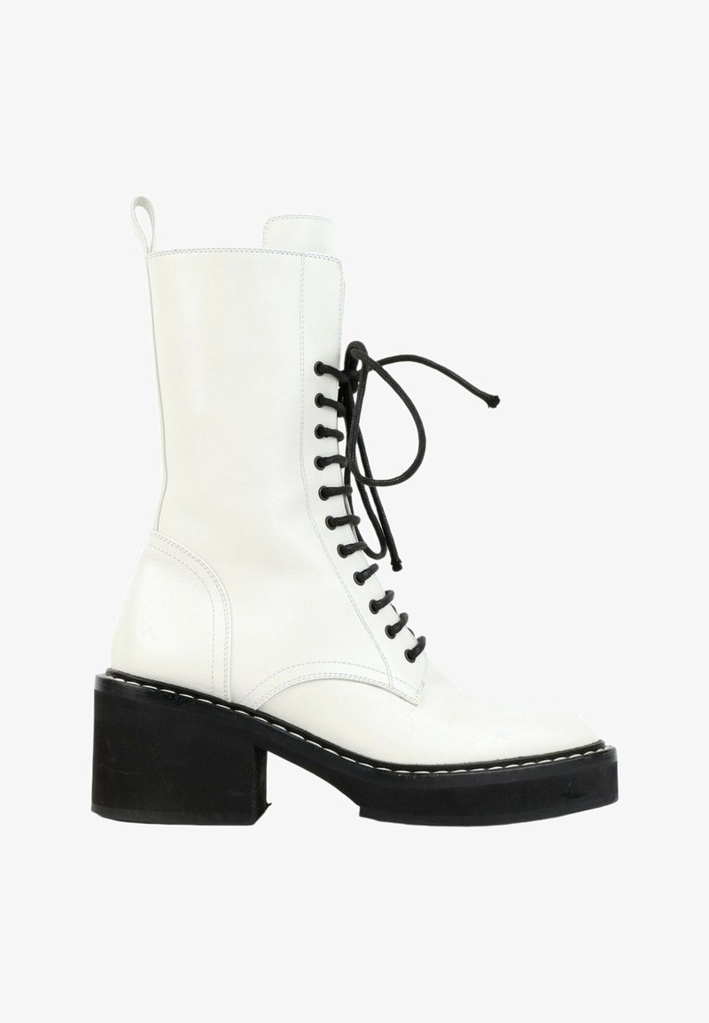 Botte blanche en cuir mi-mollet avec talon et semelle noirs épais, lacets noirs noués en nœud et languette à l'arrière.