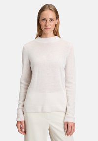 Jasnoróżowy sweter z długim rękawem i wysokim kołnierzem. Wykonany z miękkiego, dzianinowego materiału z prążkowanymi mankietami i dołem. Prosty design, bez wzorów.