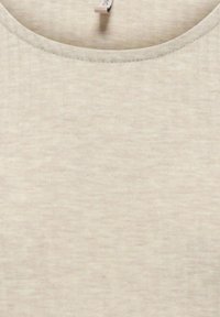 Gros plan sur un tissu côtelé beige avec un col rond et une petite étiquette blanche visible à l'intérieur du col.