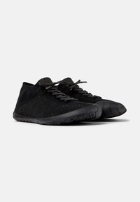 Baskets de sport noires avec une tige en tricot texturé et une semelle en caoutchouc, dotées de lacets et d'un design minimaliste. Convient pour une utilisation active.