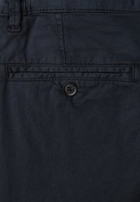 Tissu bleu marine foncé avec une texture lisse, comprenant une poche arrière avec une fermeture à bouton noir et des coutures discrètes le long des bords.