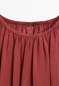 Rust red gathered linen skirt waistband with elastic band and Massimo Dutti label sewn inside.
