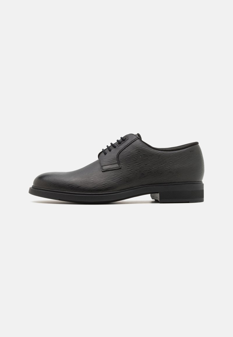 Chaussure habillée en cuir noir avec une finition texturée, bout arrondi, lacets et semelle plate. Présente un design élégant avec des accents discrets.