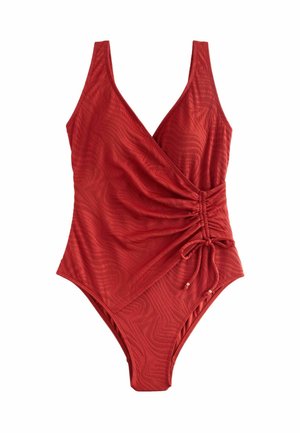 Red one-piece swimsuit with wrap front, ruched side detail, and adjustable tie on a textured fabric background.