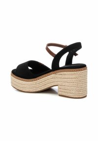 Sandal de plataforma de ante negro con tacón de cuerda trenzada. Presenta una correa curva y una correa para el tobillo ajustable para un ajuste seguro.