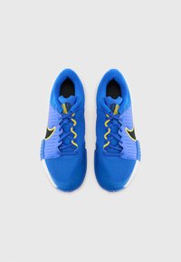 Blaue Sportschuhe aus Netzgewebe, weiße Sohle, schwarze Akzente und gelbe Schnürsenkel. Sie verfügen über ein strukturiertes Design und eine geschwungene Zehenform.