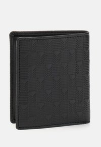 Portefeuille en cuir noir présentant un motif texturé de chevrons entrelacés, avec des bords cousus et un logo discret.