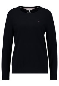 Tmavě modrý svetr s dlouhými rukávy, kulatým výstřihem, žebrovaným lemem a manžetami, s malou logo cedulkou na hrudi. Hladká textura.