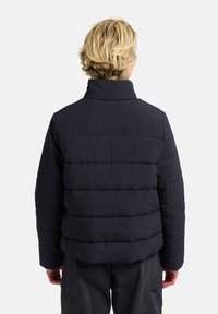 Giubbotto imbottito blu navy con colletto alto, design trapuntato e finitura testurizzata. Presenta una linea dritta e nessun elemento hardware visibile.