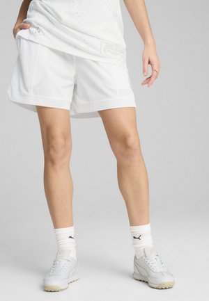 Pantaloni corti bianchi in rete con vestibilità comoda, caratterizzati da un motivo testurizzato e una vita a contrasto. Abbinati a sneaker bianche e calzini alla caviglia.