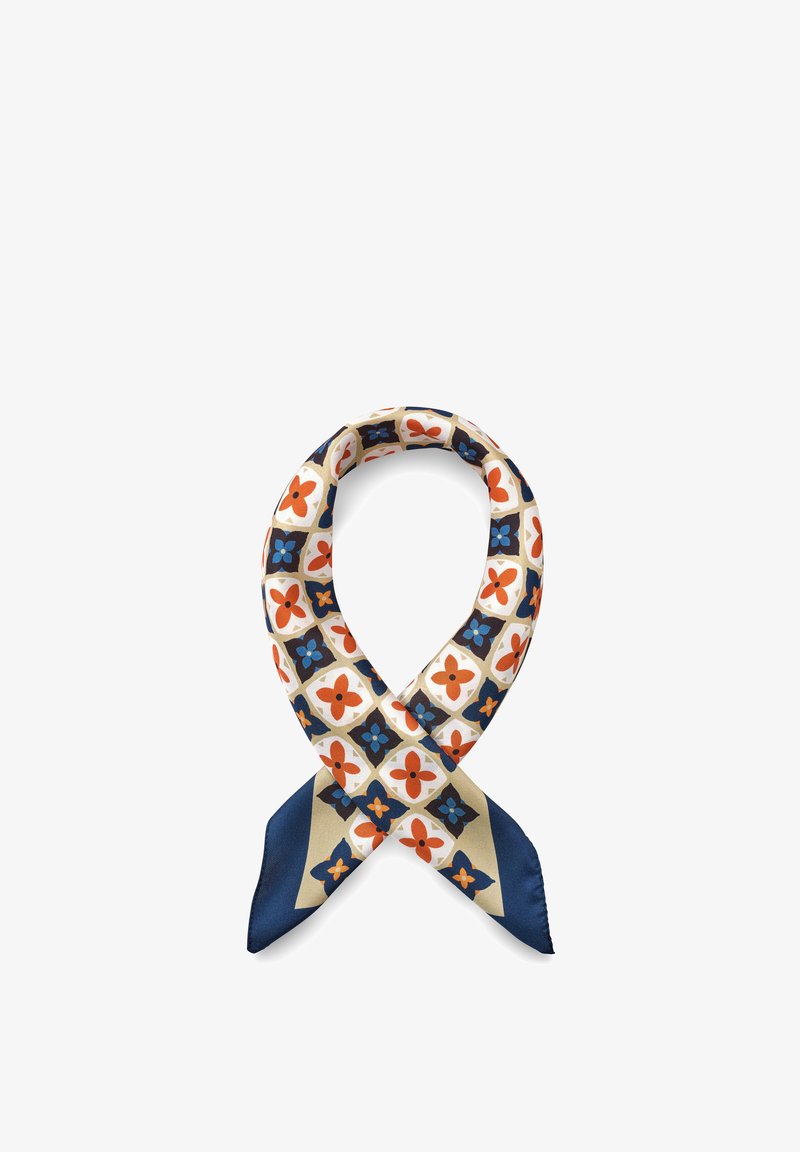 Silkeskjerf bundet i en løs knute, med et geometrisk blomstermønster i oransje, blått, beige og hvitt på en hvit bakgrunn.