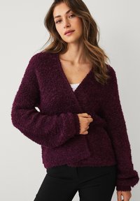 Gestructureerd, diep paarse cardigan met een V-hals, lange mouwen en een losse pasvorm, voorzien van geribbelde manchetten en een detail van een zak aan de voorkant.