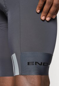 Halli tsükliajakad siledast materjalist, musta brändingu ja peegeldava aktsendiga nähtavuse tagamiseks.