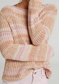 Maglione lavorato a maglia in tonalità pesca e crema con una vestibilità ampia, scollatura larga e motivo testurizzato. Caratterizzato da maniche lunghe e orlo rilassato.