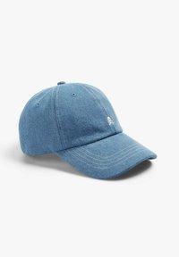Blaue Denim-Baseballmütze mit weißen Nähten, gebogenem Schild, verstellbarem Riemen und einem kleinen gestickten Totenkopf-Logo auf der Vorderseite.