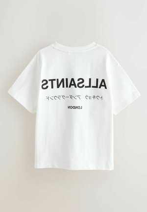 Balti medvilniniai trumpomis rankovėmis marškinėliai. Ant nugaros juodu šriftu parašyti žodžiai „ALLSAINTS“ ir „LONDON“ įvairiais tipografijos stiliais.