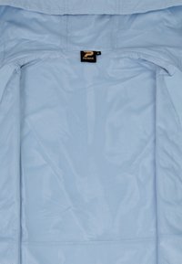 Light blue jacket with a mesh interior, featuring a logo tag labeled "PATRICK" and a medium size indicator. Soft, textured fabric.