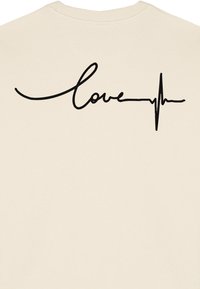 Felpa beige con testo "love" in nero in corsivo integrato con una linea del battito cardiaco, texture liscia e scollatura a coste.
