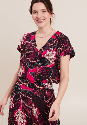 Korte mouwen blouse met een levendig bloemen- en geometrisch patroon in roze, zwart en wit, gemaakt van lichtgewicht stof met een V-hals ontwerp.