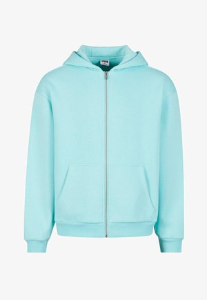 Hele sinine lukuga kapuutsiga jope, mis on valmistatud pehmest kangast, sisaldab esist oppotaskut, reguleeritavat kapuutsi ning soonikkoes Manchette ja hemmi.