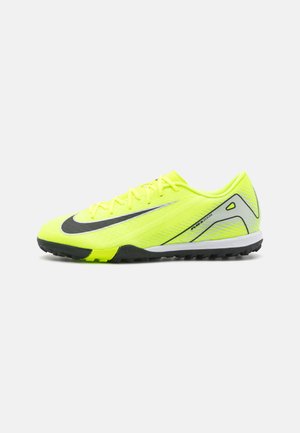 Felle gele sportschoenen met een gestructureerde mesh bovenkant, zwart swoosh ontwerp, platte veters en een contrasterende grijze zool met grip.