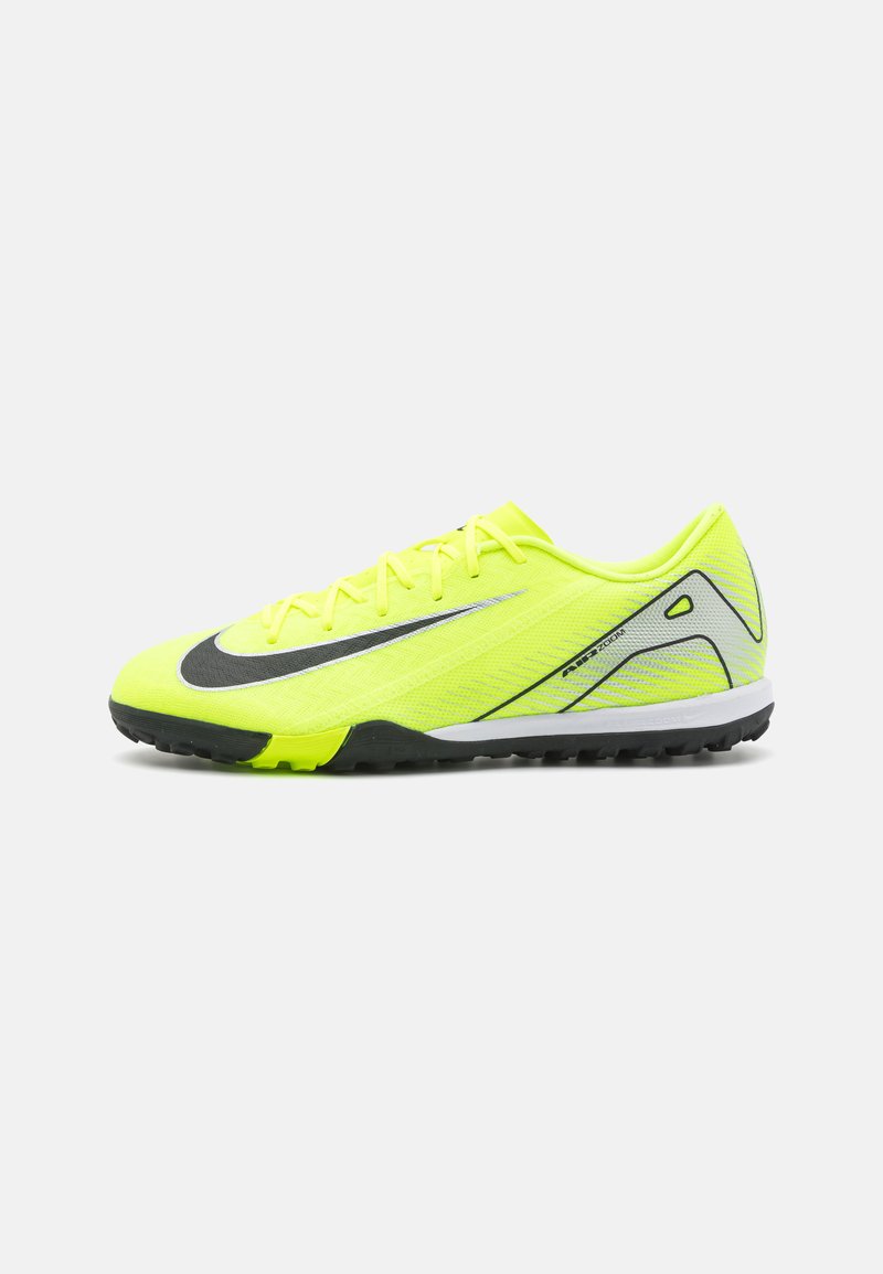 Lyse gule sportssko med en tekstureret mesh-overdel, sort swoosh-design, flade snørebånd og en kontrastrig grå sål med greb.