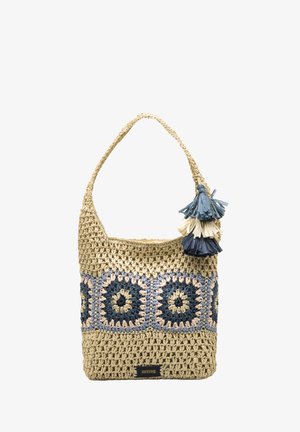 Sac à main en paille tressée de forme arrondie, présentant des motifs circulaires bleu, beige et marine, avec un accent pompon bleu et crème.