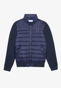 Mörkblå jacka med ett kviltat övre avsnitt, solida ärmar, två fickor med dragkedja och ribbade muddar och nederkant.